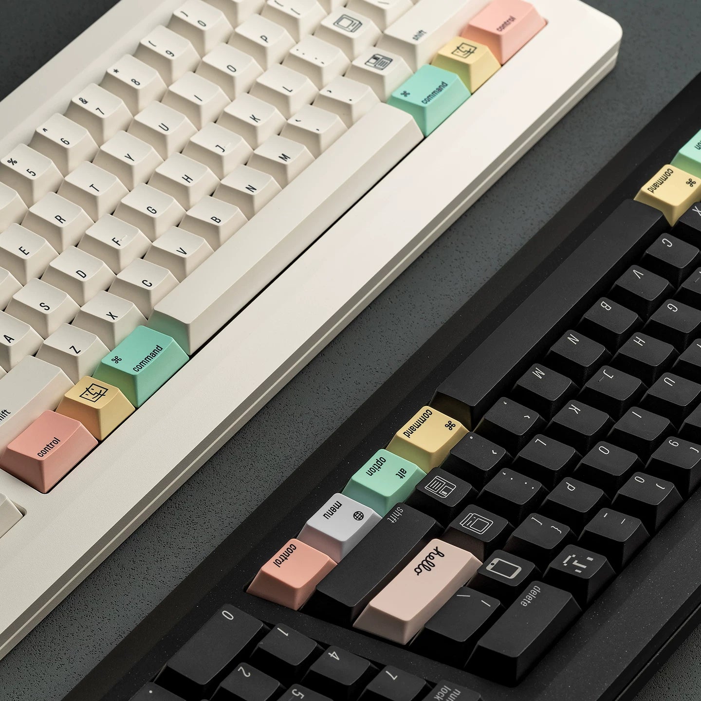 Close-up of two mechanical keyboards with colorful keycaps on a dark surface.