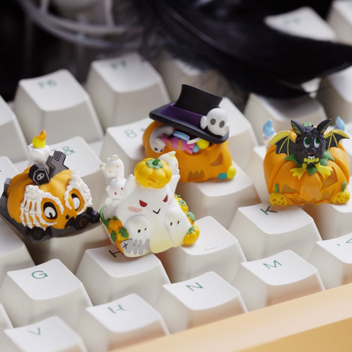 OZO Keyboards artisan Halloween-themed keycaps featuring pumpkin, ghost, and bat designs on a white mechanical keyboard
