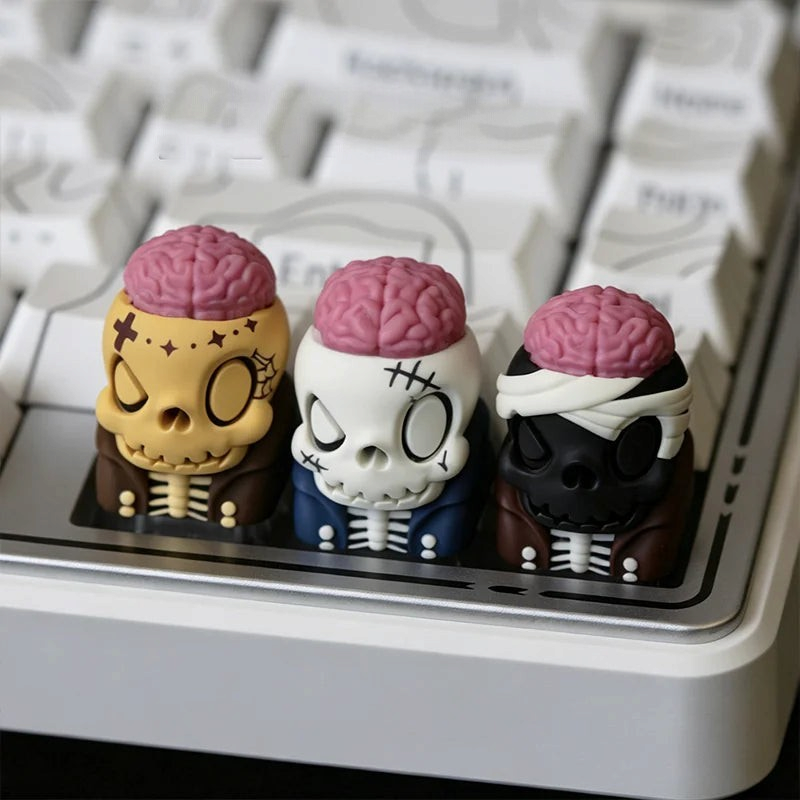 OZO Keyboards artisan keycaps featuring three unique skull designs with exposed pink brains on a mechanical keyboard