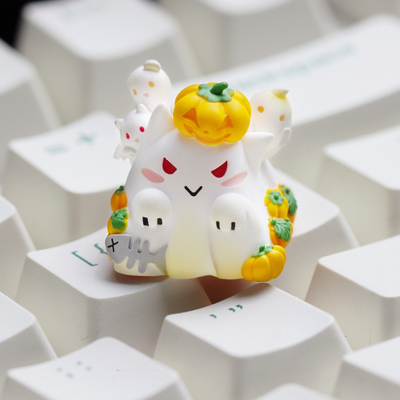 OZO Keyboards artisan keycap featuring a white cat ghost character with a pumpkin, ghosts, and fish bone on a keyboard