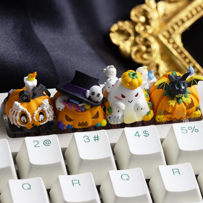 OZO Keyboards Halloween themed artisan keycaps featuring pumpkin, ghost, and bat designs on a white mechanical keyboard