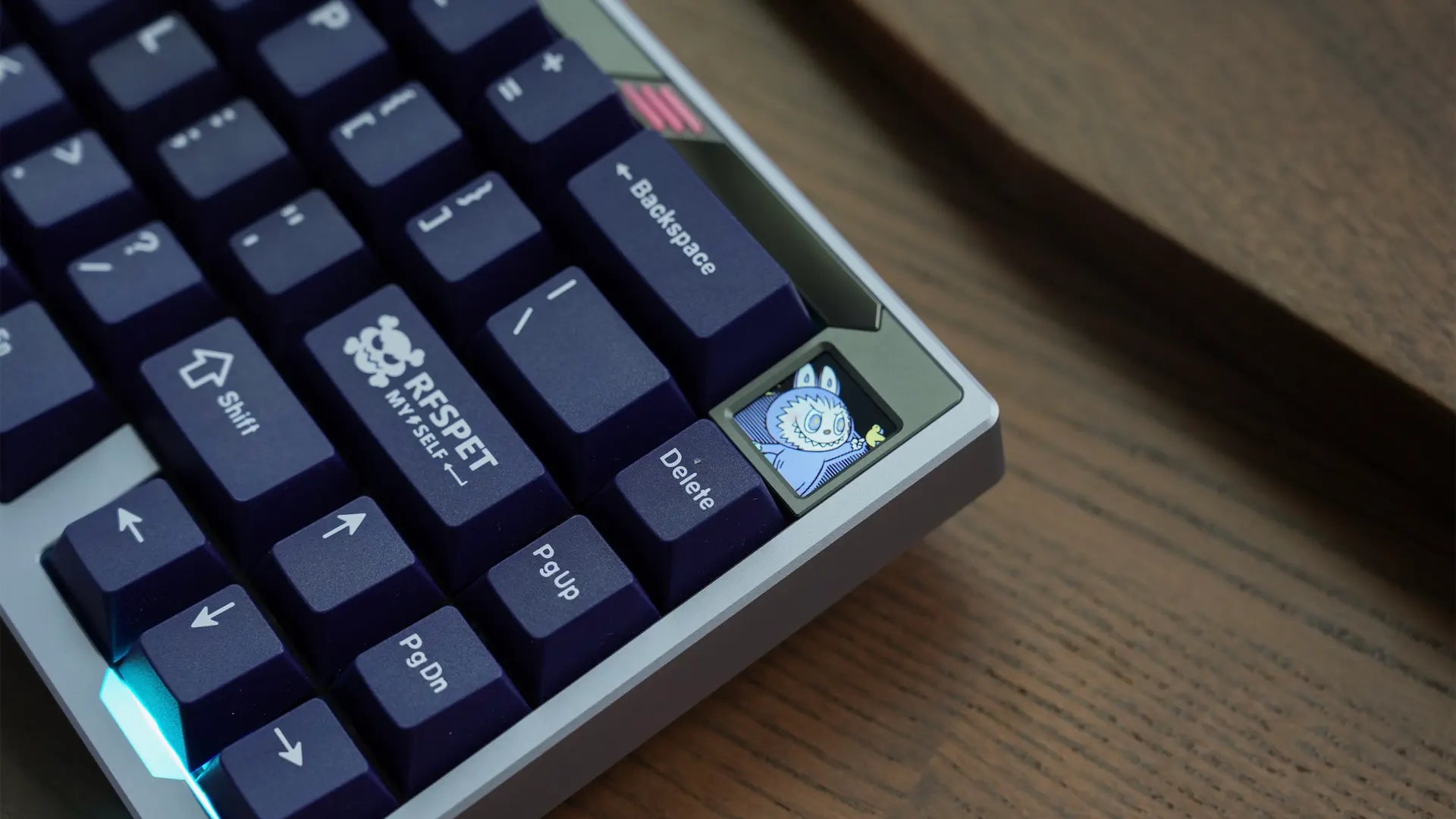 Close-up photo of a paper65 keyboard 1U screen rendering a small image of a cartoon character.
