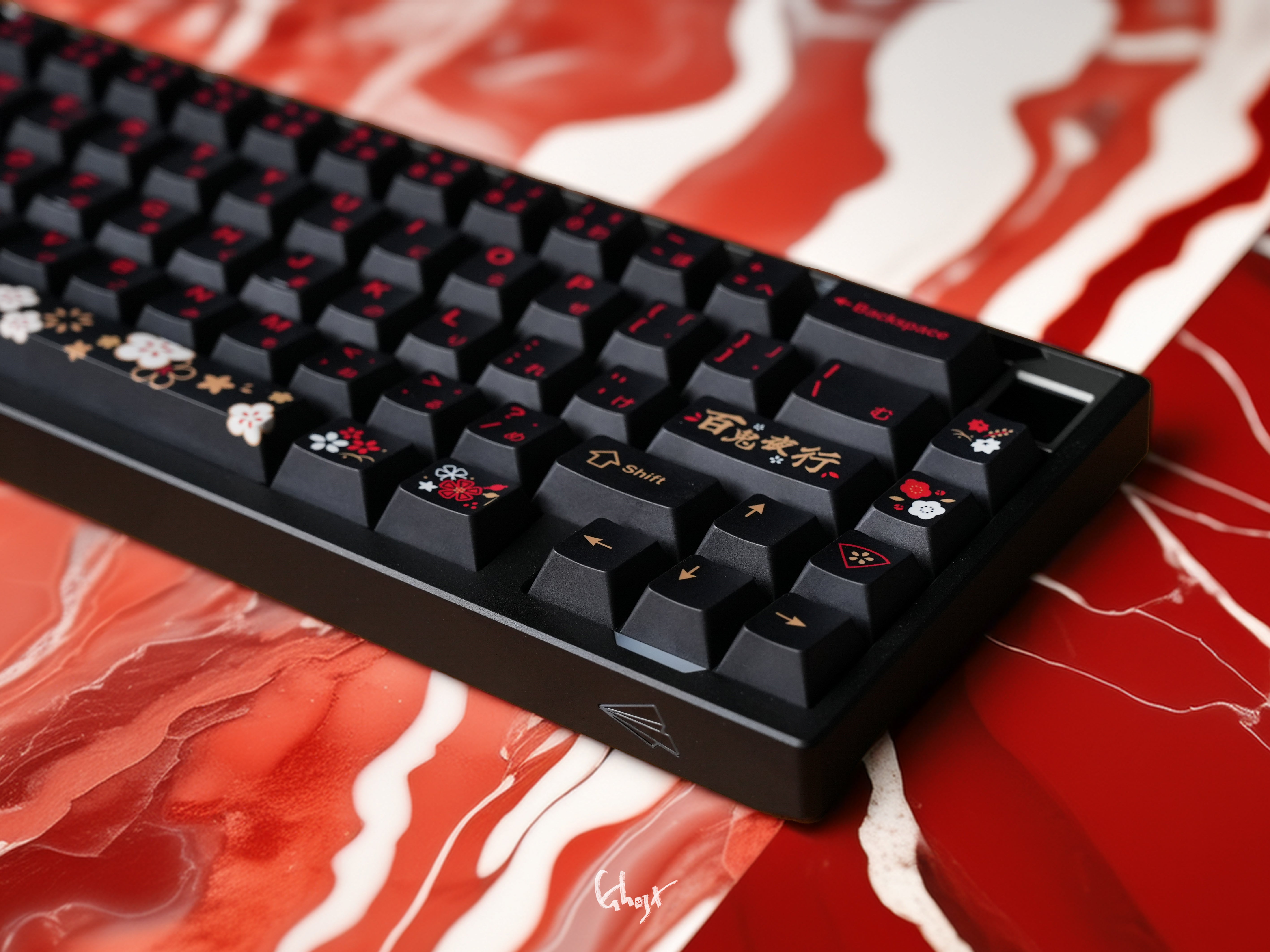 Black keyboard with decorative keycaps on a red and white marbled surface